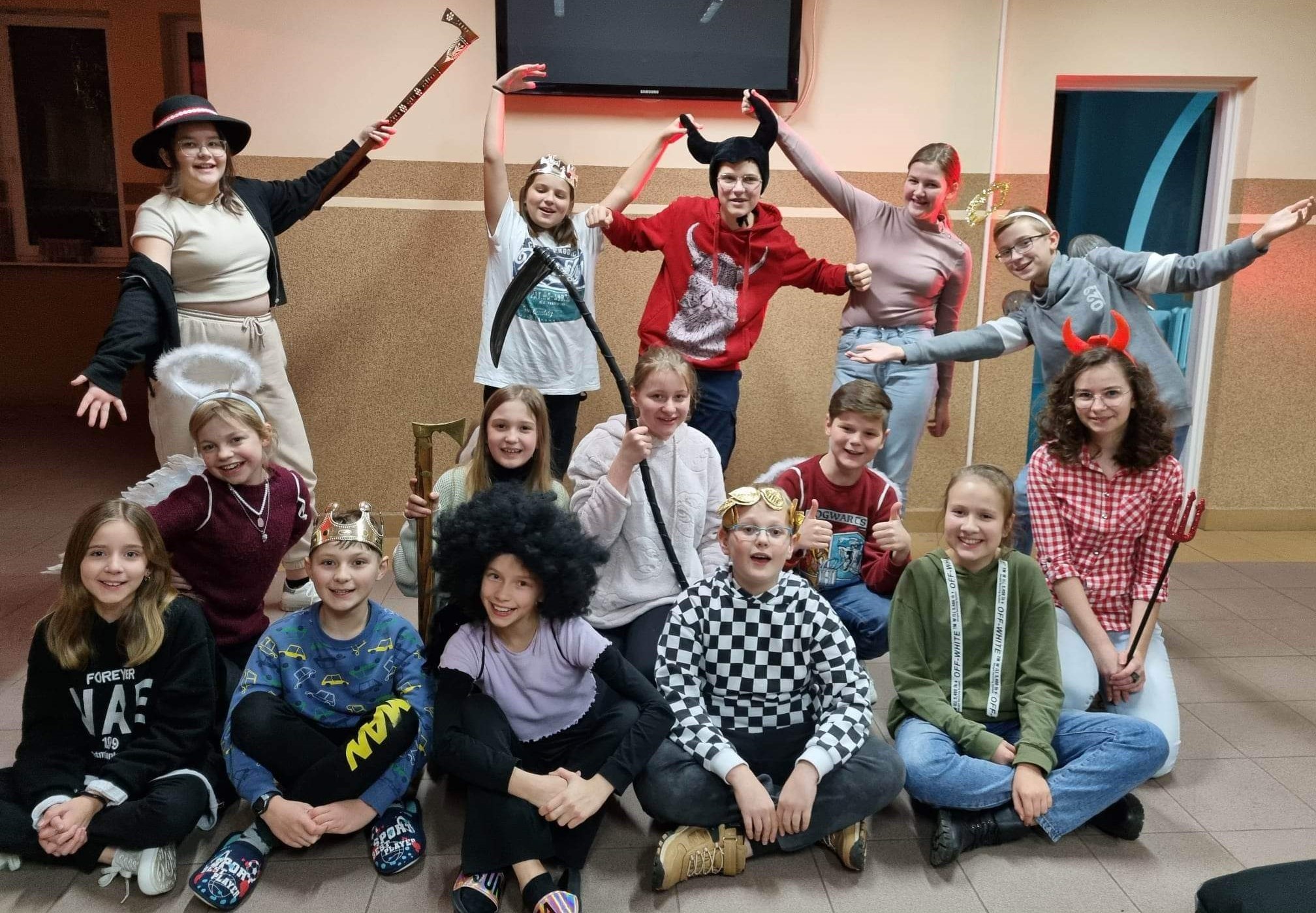 Grupa młodzieży przebrana w stroje diabła, króla, anioła, która uczestniczy w zajęciach teatralnych organizowanych w GOKiB w Rutkach-Kossakach.